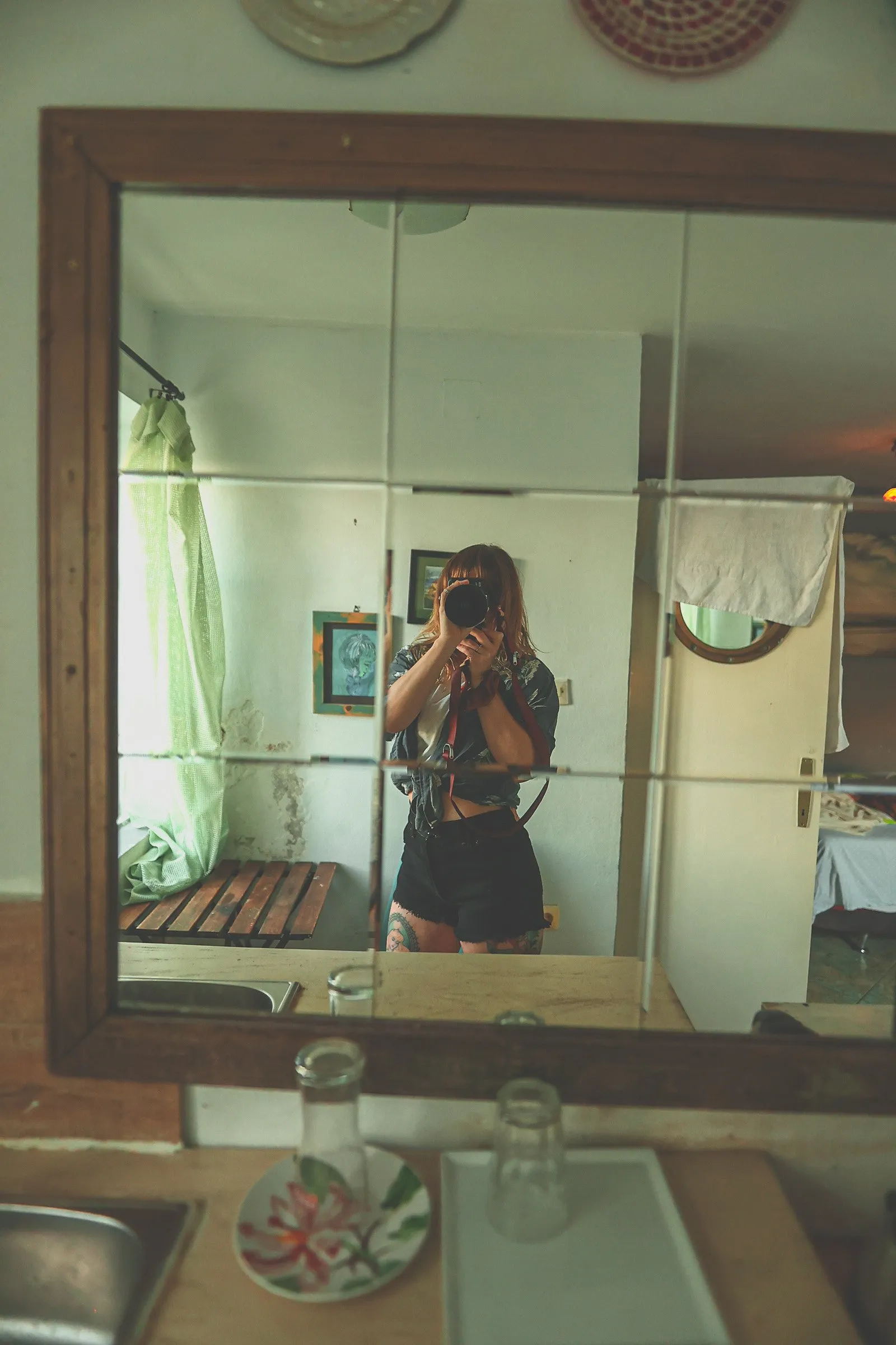 tess takes a photo of herself in a tiled mirror with a big camera